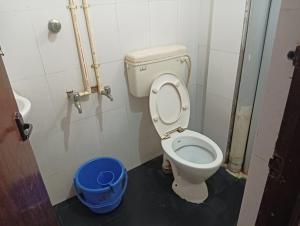 uma casa de banho com WC e um balde azul em Hotel Ambika Palace em Chennai