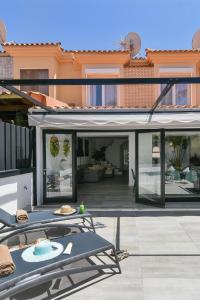 um pátio com uma mesa e cadeiras numa casa em Duplex Los Tinos II 32 by VillaGranCanaria em Maspalomas