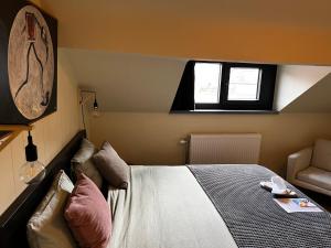 a bedroom with a bed and a couch and a window at Escape in Leuven - self check in in Leuven