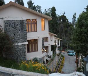 une maison avec une voiture garée devant elle dans l'établissement Mango Hill Kodai, à Kodaikānāl