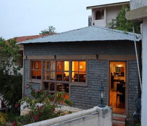 une petite maison en briques avec sa porte ouverte dans l'établissement Mango Hill Kodai, à Kodaikānāl