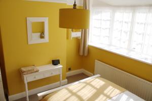 a yellow bedroom with a bed and a window at Charming 1800s Port Sunlight Worker's Cottage in Port Sunlight