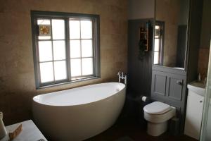 a bathroom with a tub and a toilet and a window at Charming 1800s Port Sunlight Worker's Cottage in Port Sunlight