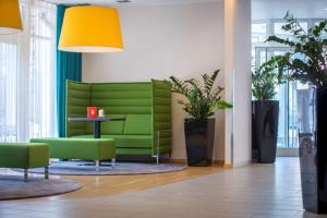 a green couch in a room with a table and plants at Park Inn by Radisson Nürnberg in Nürnberg