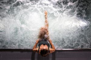 una persona che galleggia in una piscina d'acqua di Hilton Rijeka Costabella Beach Resort And Spa a Fiume (Rijeka)