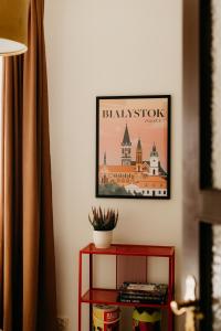 a red shelf with a picture of a building on the wall at Flathouse Apartment 2 Centrum in Białystok