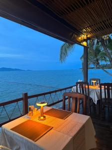 a dining table with a view of the ocean at Adarin Beach Resort in Mae Nam