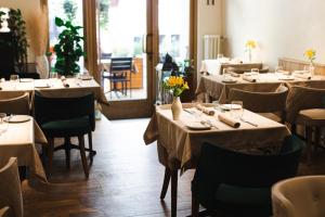 a dining room with tables and chairs with flowers on them at Dome Hotel in Rīga