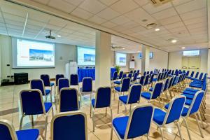 una sala conferenze con sedie blu e schermo di Hotel Dei Principati a Baronissi