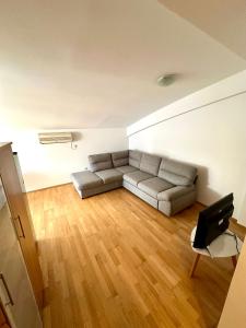 uma sala de estar com um sofá, uma mesa e uma televisão em Apartment Stex 3 em Podgorica