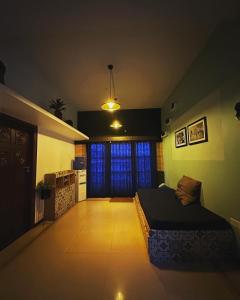 a bedroom with a bed in the middle of a room at Ganga's Sri Balaji Cottage in Ooty