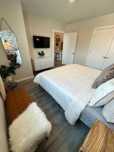 una camera con letto bianco e TV di Home Haven, Walk to Little Italy & Wooster Square a New Haven