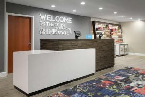 Hampton Inn & Suites Tampa Ybor City Downtown في تامبا: كونتر ترحيب في متجر مع ترحيب بأشعة الشمس