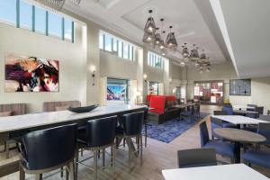 Hampton Inn & Suites Tampa Ybor City Downtown في تامبا: مطعم بطاولات وكراسي وبار