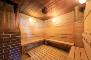 een lege sauna met houten banken en een bakstenen muur bij Hotel Pony Onsen in Towada