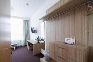 a hotel room with a desk and a room at Mini Hotel Akord in Ostrava