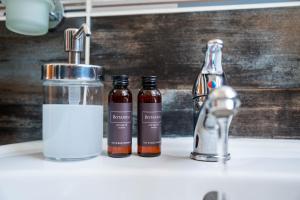 two bottles of soap on a sink next to a faucet at Mini Hotel Akord in Ostrava