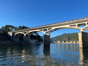 een trein die een brug over het water oversteekt bij Casa de Casarelhos - Gerês - Estúdio com AC e AL com lareira in Geres