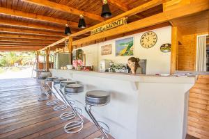 un bar avec une rangée de tabourets dans un restaurant dans l'établissement Mare E Monti, à Porto Pollo