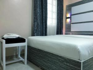 a bedroom with a white bed and a window at Mt. Everest Hotel in Kisii