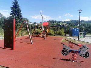 um parque com um baloiço e um parque infantil em Pokoje i Apartament U Ireny em Poronin