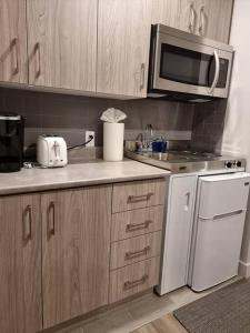 een keuken met een wastafel, een fornuis en een magnetron bij Cozy Sweet Studio #9. Ten min to D.T Ottawa in Gatineau