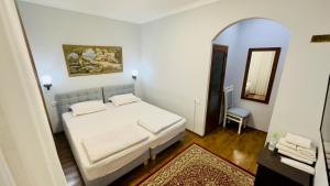 una camera con letto bianco e specchio di Samarkand Travel a Samarkand