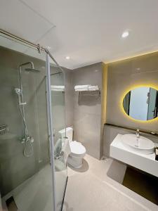 a bathroom with a shower and a toilet and a sink at Sunflower Hotel & Resort in Bao Loc