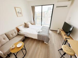 Habitación pequeña con cama y sofá en SR難波 Sanctuary Residence, en Osaka