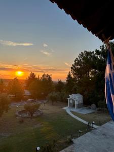 een zonsondergang boven een park met een prieel bij Archontiko Alexandros Luxury Suites in Kardiá