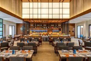 une salle à manger avec des tables et des chaises ainsi qu'une bibliothèque dans l'établissement Fairfield by Marriott Goa Benaulim, à Benaulim