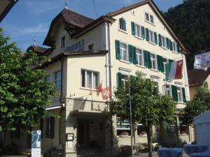 a large white building with green shutters at Hasli Lodge in Meiringen