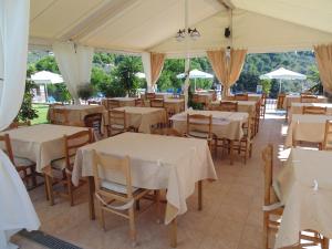 un restaurante con mesas blancas, sillas y sombrillas en Skiathos Diamond, en Kolios