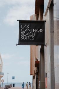 um sinal preto no lado de um edifício em Las Canteras Beach Suites em Las Palmas de Gran Canárias