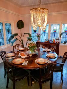 a dining room with a table with chairs and a chandelier at Inn at Rose Hall in Eureka Springs