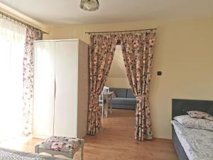 um quarto com uma cama, um sofá e cortinas em Pokoje i Apartament U Ireny em Poronin