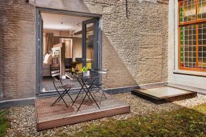 a patio with a table and chairs next to a brick wall at Hotel Nassau Breda, Autograph Collection in Breda