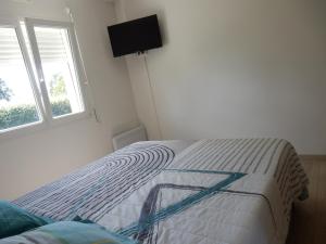 uma cama num quarto branco com uma janela em Maison 3 chambres 120m2 3km ploermel em Ploërmel