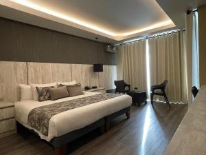 a hotel room with a bed and a desk and chair at Hotel Catena in Cochabamba