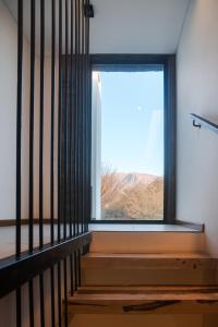 Habitación con ventana y escalera de madera. en DEPARTAMENTOS TERRAZAS DE CAFAYATE, en Cafayate