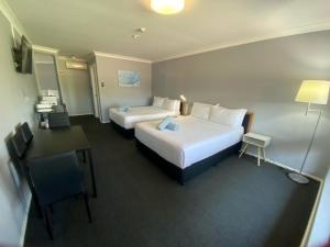 um quarto de hotel com duas camas e uma secretária em Old Maitland Inn em Maitland