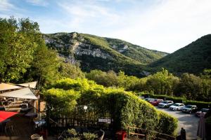 un estacionamiento con autos estacionados frente a una montaña en Le Belvedere, en Vallon-Pont-dʼArc