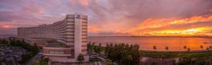 ein großes Gebäude mit Sonnenuntergang im Hintergrund in der Unterkunft Hilton Tokyo Bay in Urayasu