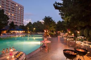 einen Pool mit Tischen und Stühlen neben einem Gebäude in der Unterkunft Hilton Tokyo Bay in Urayasu