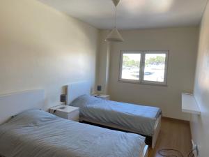 - une chambre avec 2 lits et une fenêtre dans l'établissement Zion guest house, à Almada