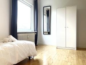 um quarto com uma cama, um espelho e uma janela em Tow-Bedroom Apartment Located In The Beautiful City Of Fredericia em Fredericia