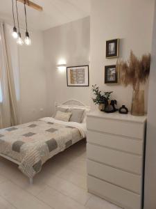 a white bedroom with a bed and a dresser at Old Town Warsaw Joanna's Apartments in Warsaw