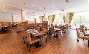 a restaurant with tables and chairs in a room at PLAZA Premium Wien in Vienna