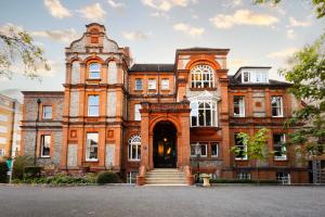 an old brick building with a staircase in front of it at Palmers Lodge Swiss Cottage in London