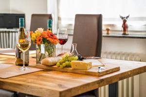 een houten tafel met wijnglazen en kaas en bloemen bij Ferienwohnung Kuckucksnest in Lahr